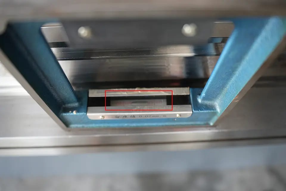 A level ruler should be placed horizontally in the middle of the press brake workbench