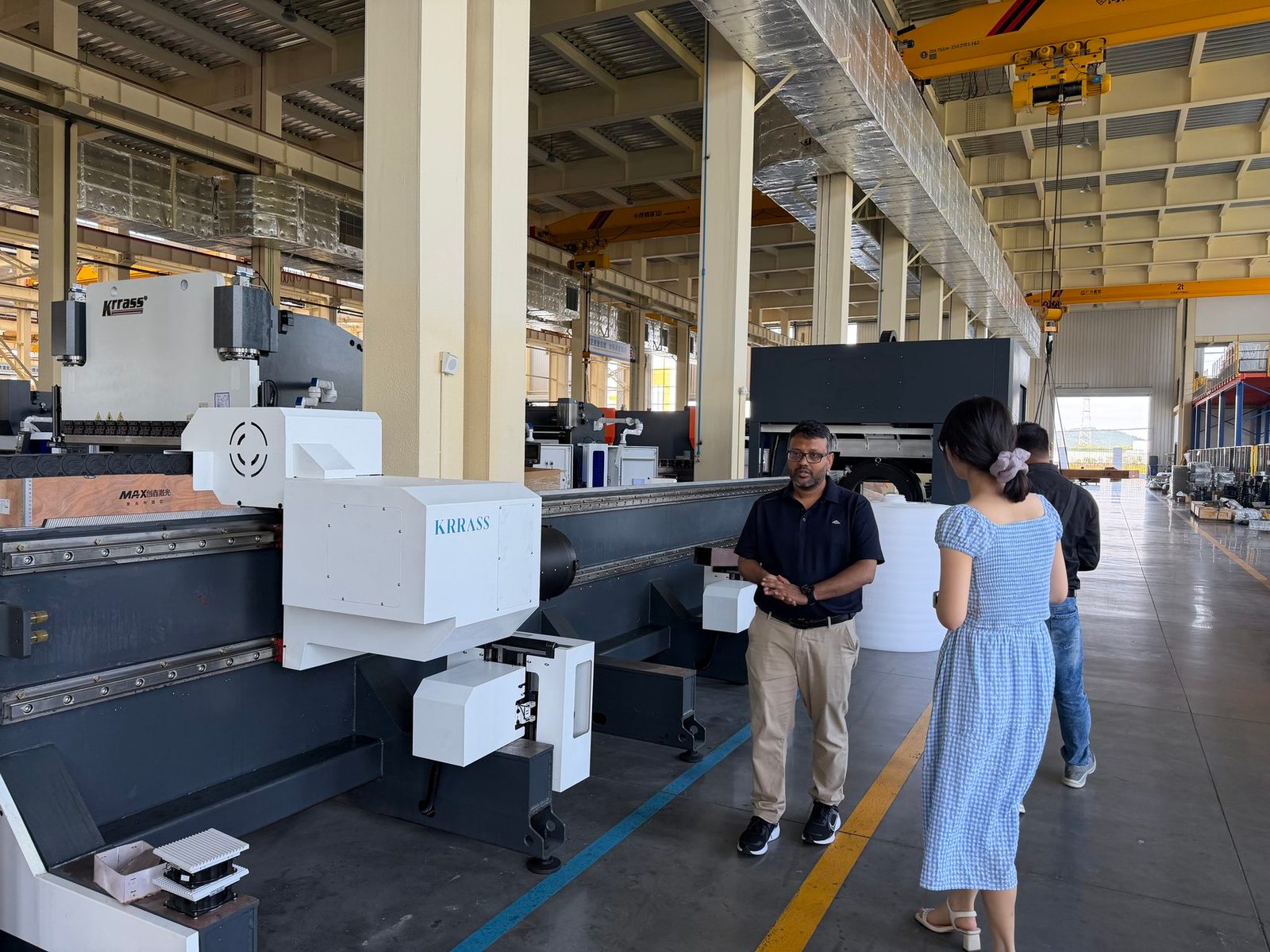 Pictures KRRASS engineers demonstrating sheet metal machinery during factory visit